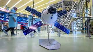 Ein Modell vom Europäische Servicemodul steht im Bremer Airbus-Werk vor dem ESM-5, an dem Arbeiten stattfinden.
