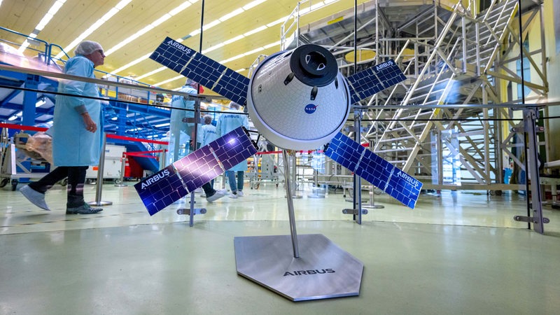 Ein Modell vom Europäische Servicemodul steht im Bremer Airbus-Werk vor dem ESM-5, an dem Arbeiten stattfinden.