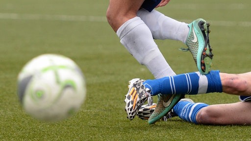 Zwei Fußballer kämpfen um einen Ball. Close-up auf die Beine