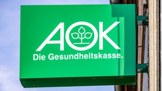 Logo der Krankenkasse AOK auf einem Schild