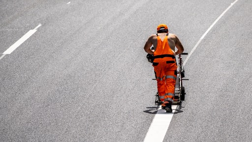 Ein Arbeiter markiert eine Fahrbahn