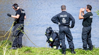 Ein Taucher der Polizei steigt in die Oste. 