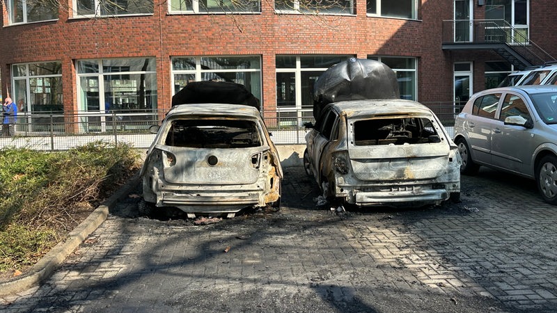 Ausgebrannte Fahrzeuge der Polizei vor einer Polizeiwache in Bremen-Mitte