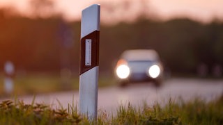 Auto fährt auf einer Landstraße.