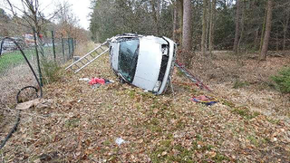 Ein Auto ist von der Straße abgekommen und liegt in einem Wald