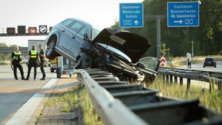 Auto liegt auf der Leitplanke 