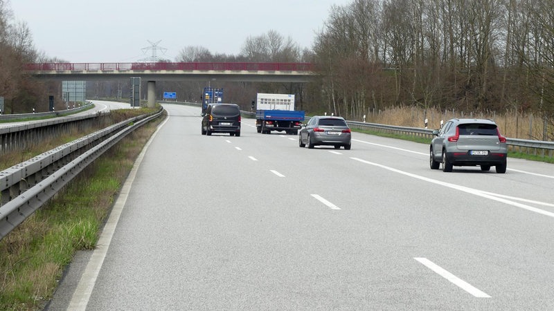 Wenige Autos fahren auf einer ansonsten leeren Autobahn.