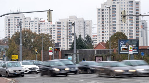 Autos fahren an den Hochhäusern im Bremer Stadtteil Tenever vorbei.