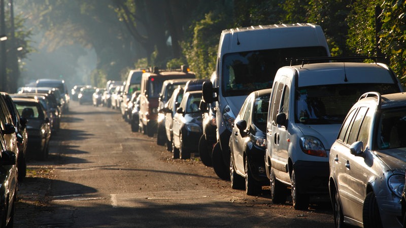 Autos pakren an beiden Rändern einer Straße.