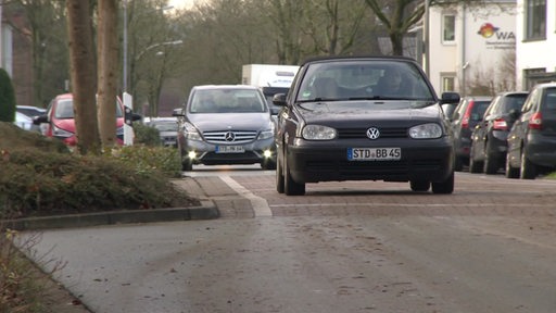 Mehrere Autos fahren über einige Bodenschwellen auf einer Straße