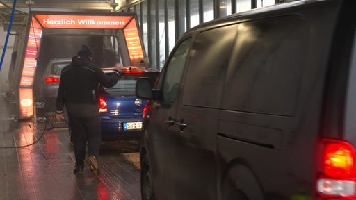 Mehrere Autos reihen sich hintereinander in einer Autowaschanlage 