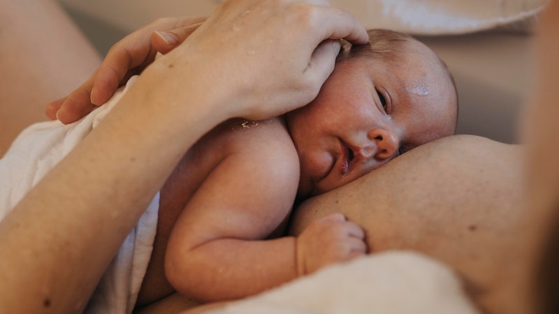 Ein Baby in den Armen der Eltern. 