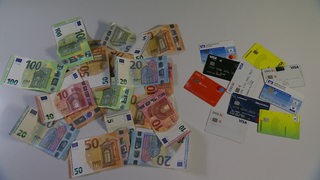 Bargeld und EC karten liegen nebeneinander auf einem Tisch.