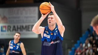 Basketball-Profi Robert Oehle konzentriert bei einem Freiwurf mit dem Basketball in der Hand.