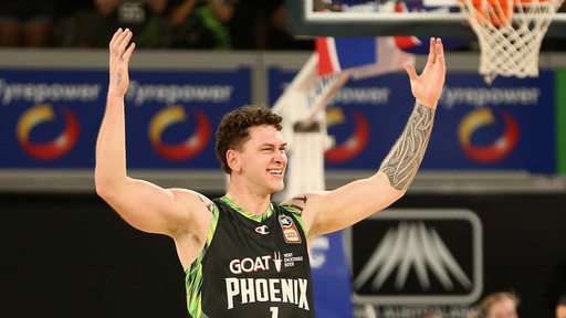 Basketballer Anzac Rissetto reißt seine Arme hoch und lacht.