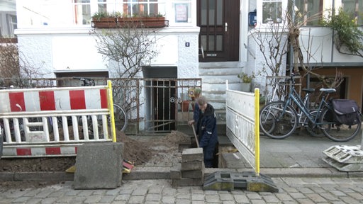 Ein Bauarbeiter beim graben an der Basutelle für ein Erdwärmenetz