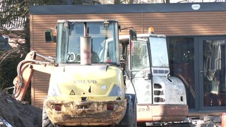 Ein Bagger steht auf der Baustelle eines Tiny House