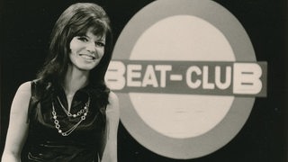 Uschi Nerke neben dem Beat-Club-Logo