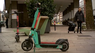 E-Scooter stehen auf dem Gehweg.