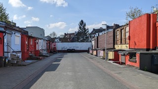 Ein Blick in eine Straße, die von niedrigen bunten Häusern gesäumt ist.