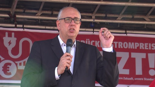 Bovenschulte hält bei der Demo am Stahlwerk eine Rede und gestikuliert mit seiner Hand