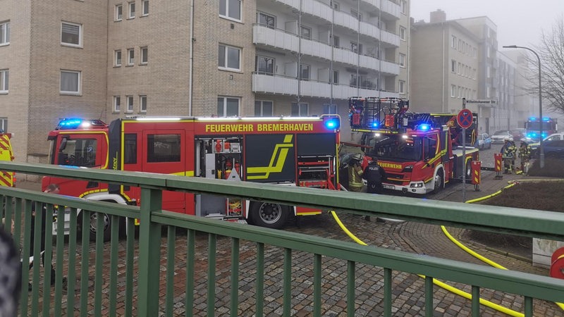 Drei Feuerwehrautos stehen vor einem Gebäude.