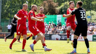 Die Spieler des FC Oberneuland rennen nach dem Sieg zu ihrem Keeper Jonas Horsch.