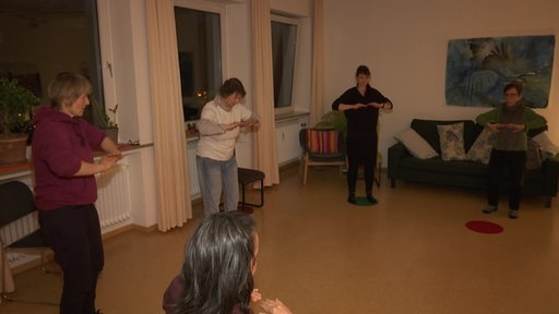 Mehrere Damen machen verschiedene Qigong Meditationsübungen 