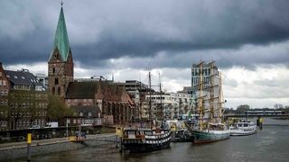 Dunkle Wolken ziehen über die Innenstadt und die Weser.