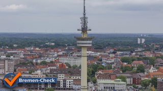 Ein hoher Fernsehturm erhebt sich überdie Stad Bremerhaven mit zahlreichen Gebäuden, der Himmel ist leicht bewölkt,