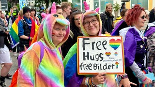 Beim CSD in Bremerhaven ziehen die Menschen demonstrierend durch die Straßen.