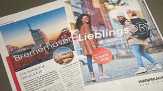 Auf einem Tisch liegen zwei Magazinseiten.