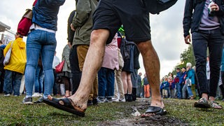 Matschige Füße in Sandalen laufen über den triefenden Boden am Osterdeich