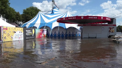 Ein Zirkuszelt und eine Bar der Breminale am Osterdeich stehen unter Wasser.