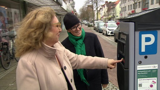 Die Mobilitätssenatorin Özlem Ünsal drückt auf die Brötchentaste beim Parkautomaten. 