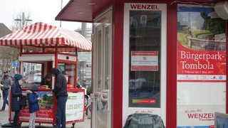 Familie vor Losbude auf dem Bremer Bahnhofsvorplatz.