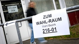 Ein Hinweisschild zeigt den Weg zu einem Wahlbüro.