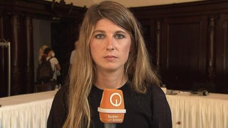 Reporterin Catherine Wenk bei einer Schalte im Bremer Rathaus.