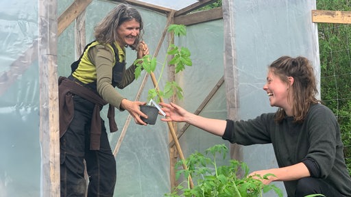 Gärtnerin Christina Wolterink und Projektleiterin Fenna Zock vor einem Gewächshaus aus Folie