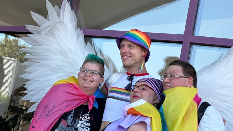 Vier Menschen lachen in eine Kamera geschminkt beim CSD Bremerhaven