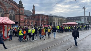 Menschen versammeln sich auf dem Platz vor dem Hauptbahnhof in Bremen.