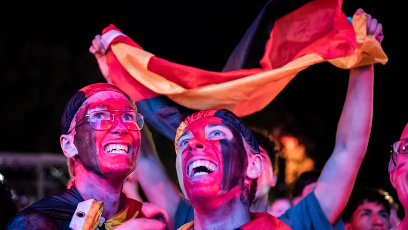 Deutschland-Fans jubeln in der Fanzone während eines Spiels der Fußball-Nationalmannschaft. 