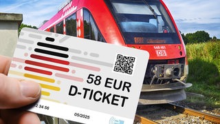 Hand hält das Deutschlandticket D-Ticket mit dem Preis von 58 Euro vor einer Regionalbahn.