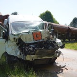 Ein beschädigter Schulbus steht an einem Bahnübergang im Landkreis Diepholz an der Unfallstelle. 