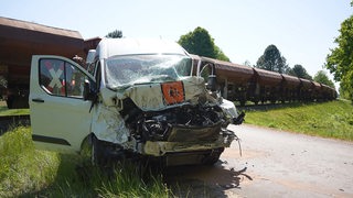 Ein beschädigter Schulbus steht an einem Bahnübergang im Landkreis Diepholz an der Unfallstelle. 