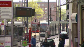 Die Haltestelle Domsheide mit mehreren Straßenbahnen und Autos im Bild.