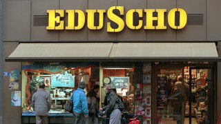 Menschen gehen an einer Filiale von Kaffeehersteller Eduscho vorbei.