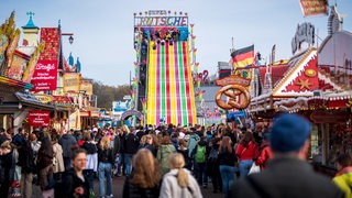 Besucher laufen über die Osterwiese auf der Bürgerweide am 12. April 2022