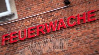 An einem Haus steht ein Schriftzug in Rot: "Feuerwache"