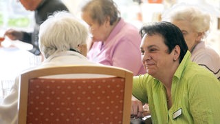 Eine Betreuerin unterhält sich mit einer Bewohnerin auf plattdeutsch über Erinnerungen aus längst vergangenen Tagen.